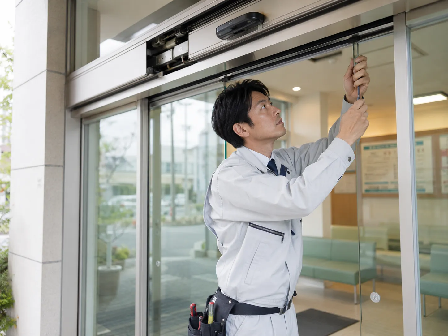自動ドアの点検と修理を行う技術者